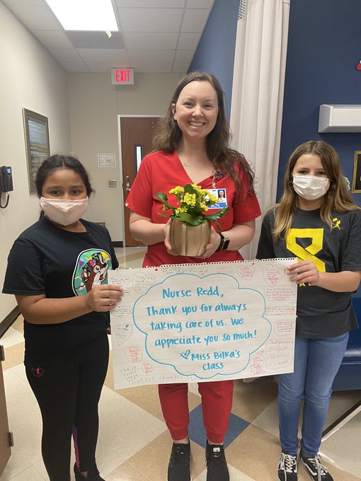 School nurse with kids  and sign