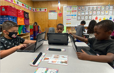 Pre-K students learning on laptops